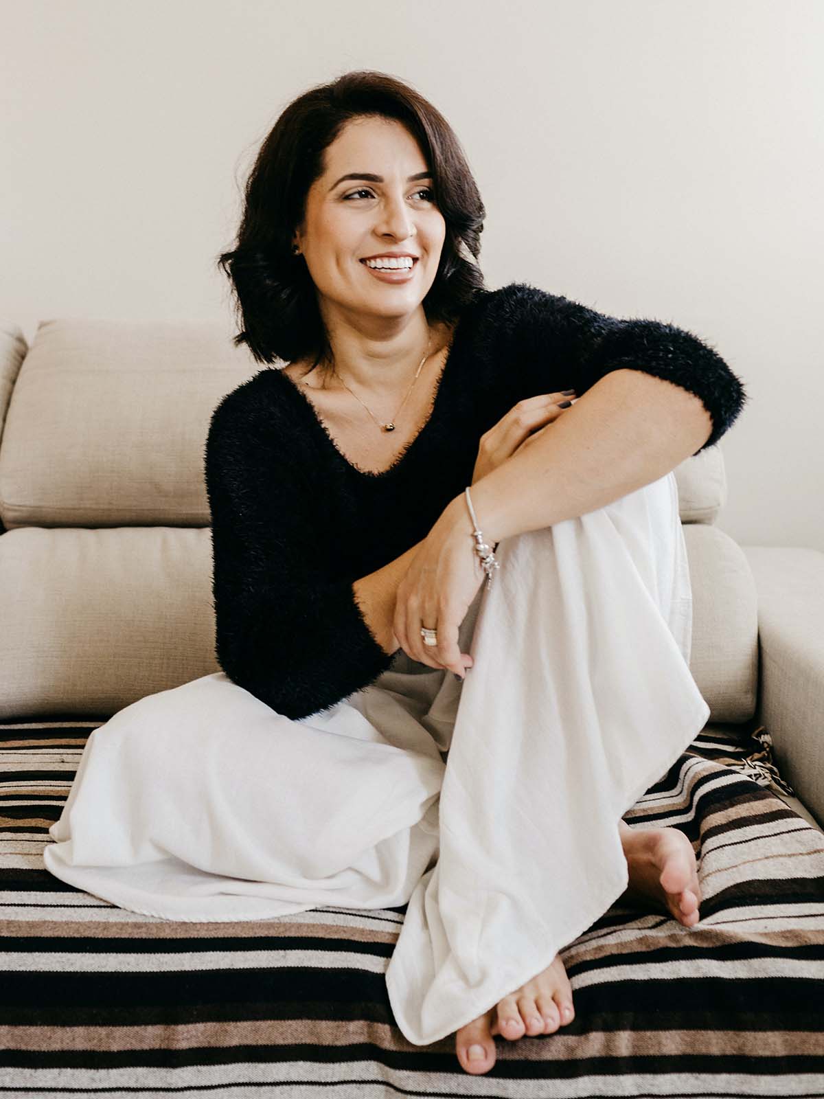 onnellinen nainen istuu sohvalla